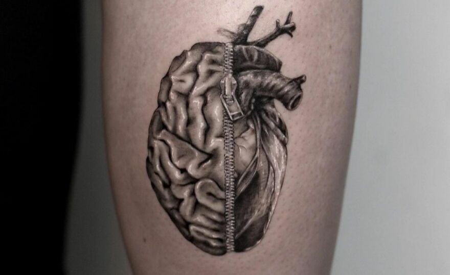 Realistic tattoo of a brain and heart zipped together with intricate detailing.