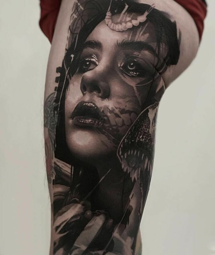 Realistic tattoo of a woman's face with intricate details and artistic shading on a person's leg.
