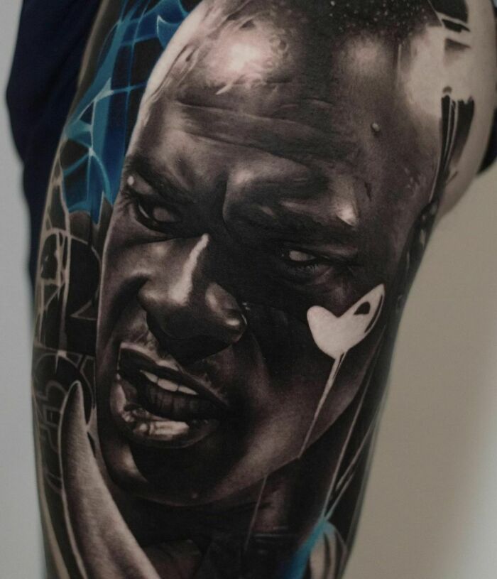 Close-up of a super realistic tattoo depicting a man's intense expression, showcasing amazing detail and artistry.
