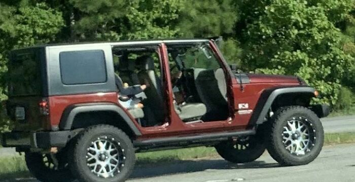 Mom Has Her Baby In A Child’s Seat In The Back Of This Jeep Going Down The Interstate Without The Doors