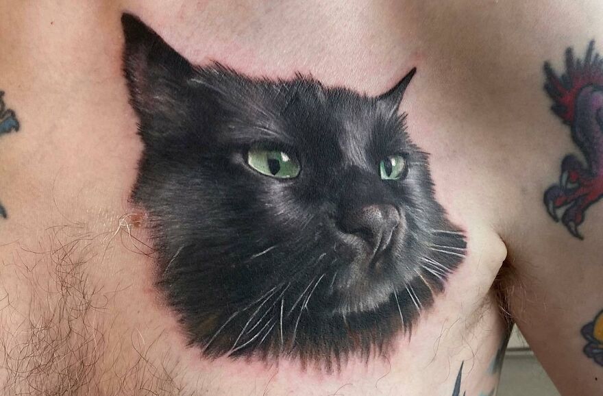 Realistic tattoo of a cat's face on a chest, showcasing amazing detailing and lifelike features.