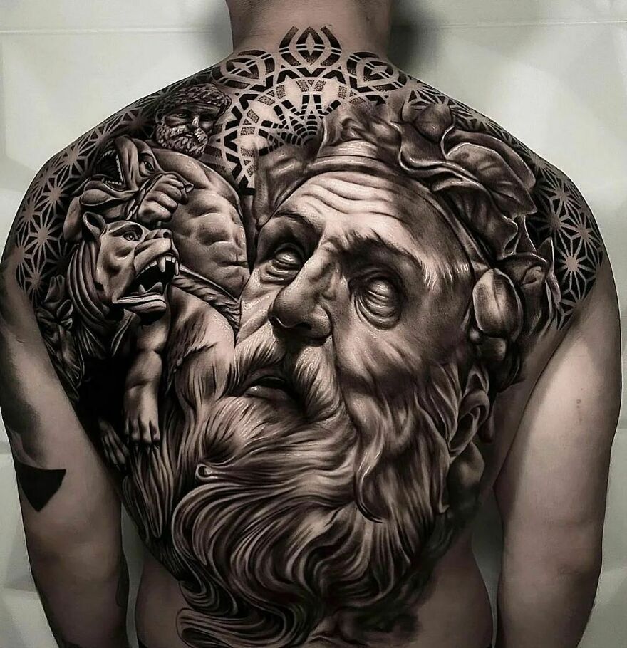 Realistic tattoo of a large bearded man's face on a back, intricately detailed.
