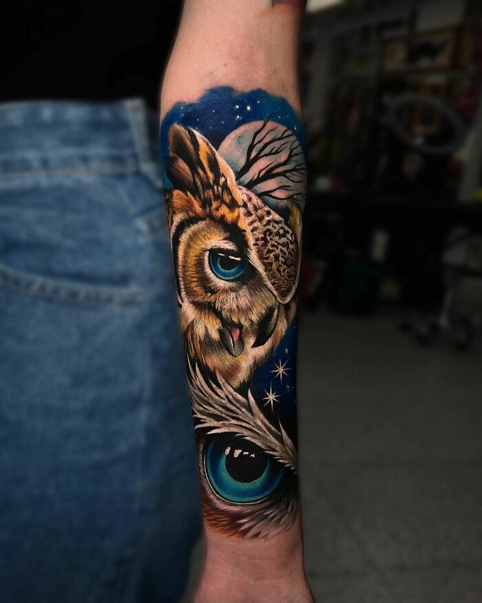 Realistic tattoo of an owl with vivid details on a forearm, showcasing artistic skill against a dark backdrop.
