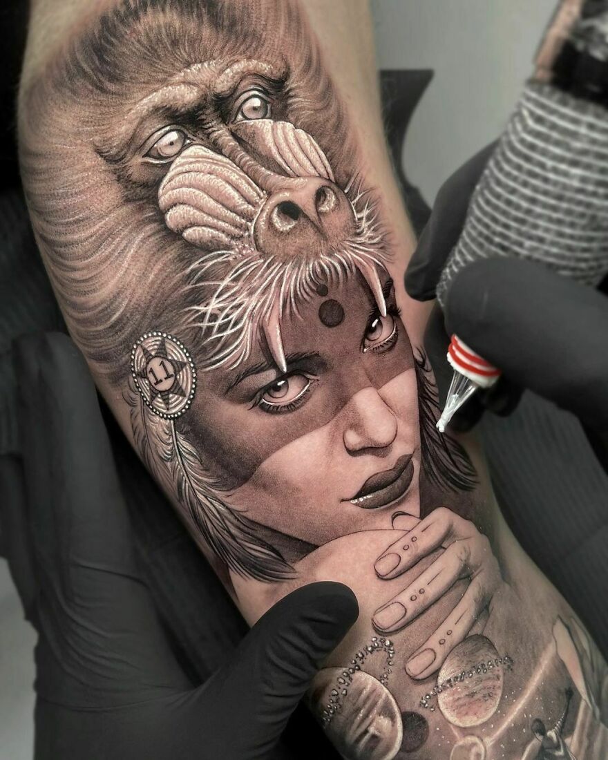 Amazingly detailed tattoo of a woman with a baboon mask on her forehead, showcasing realistic artistry.