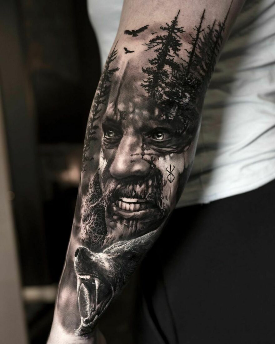 Super realistic Viking, wolf, and nature tattoo on arm, showcasing intricate detailing and artistry.