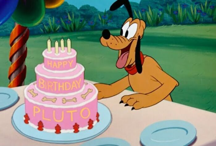 Pluto blowing candles on a birthday cake 