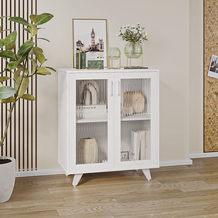 White cabinet with decor and books, a plant beside it, showcasing home organization ideas.