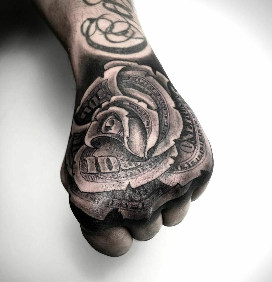 Hand tattoo featuring a detailed dollar rose design, showcasing super realistic art.