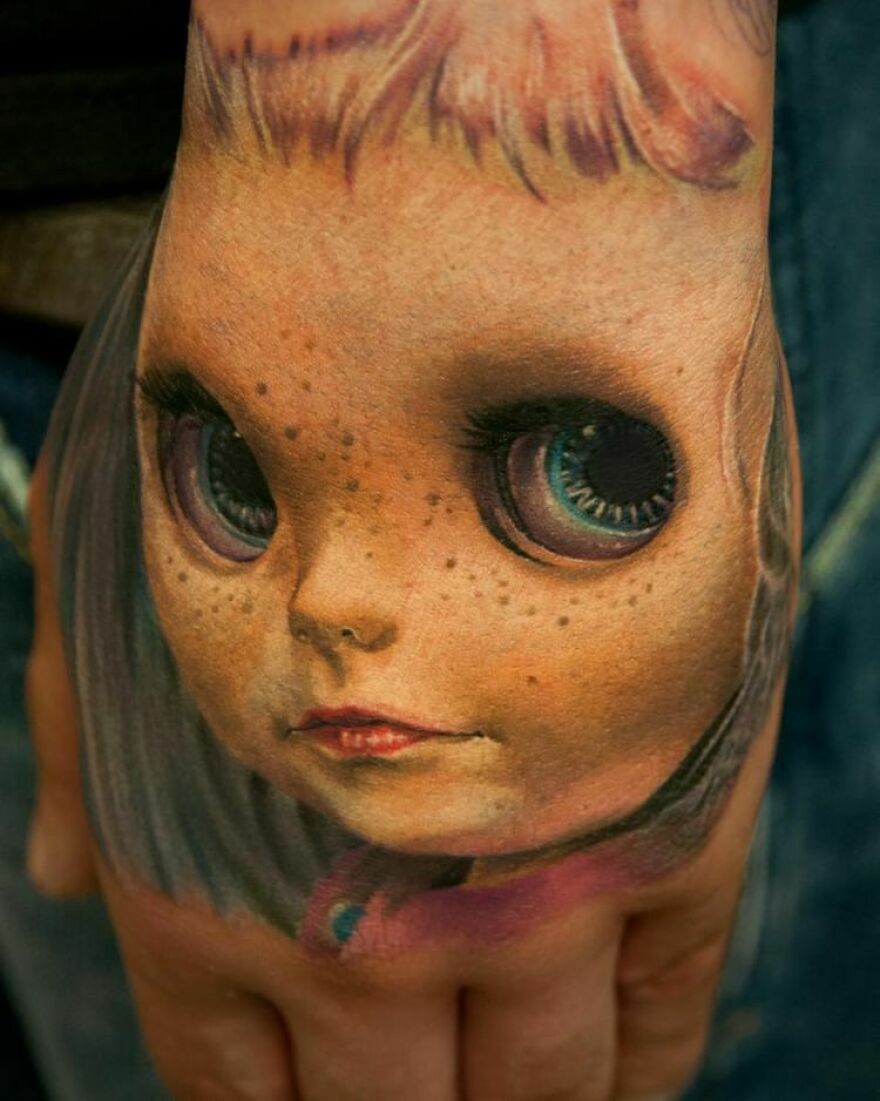 Realistic doll face on hand tattoo