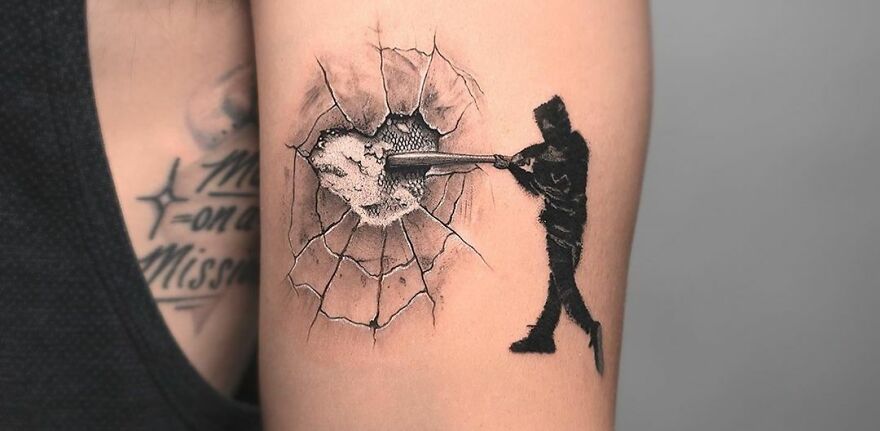 Realistic tattoo of person smashing through a wall on arm.