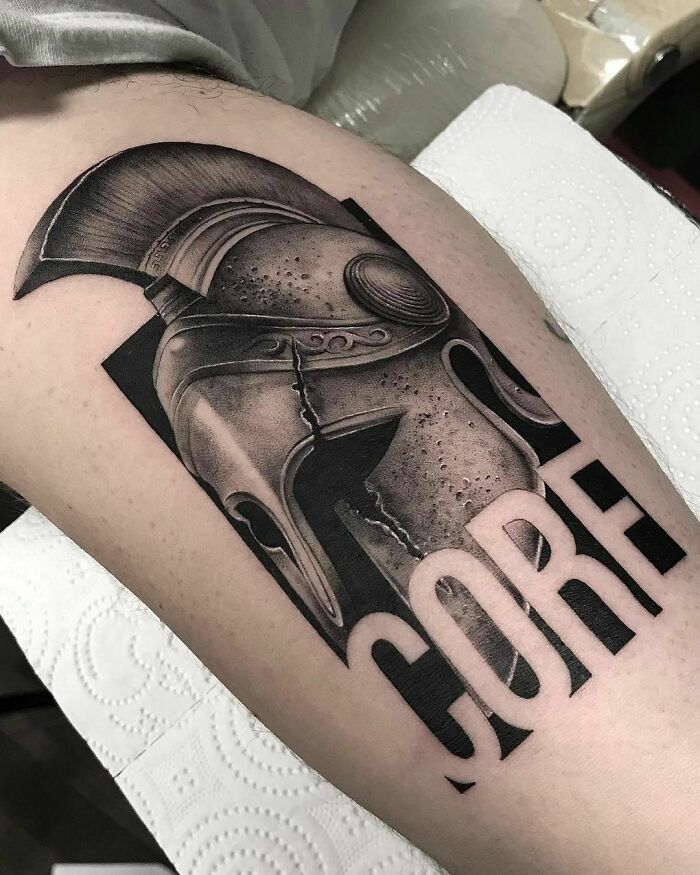 Realistic tattoo of a detailed Roman helmet with the word "CORE" on skin.