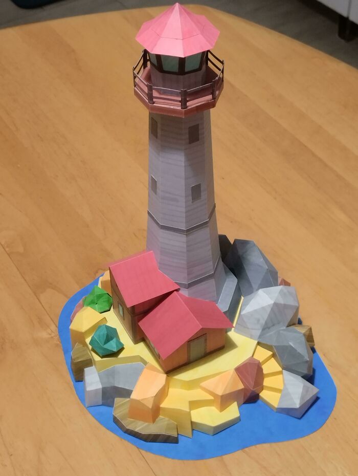 Lighthouse on rocks made out of a paper