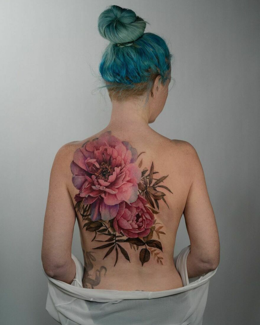 Large pink peonies tattoo on back, showcasing realistic detailing.