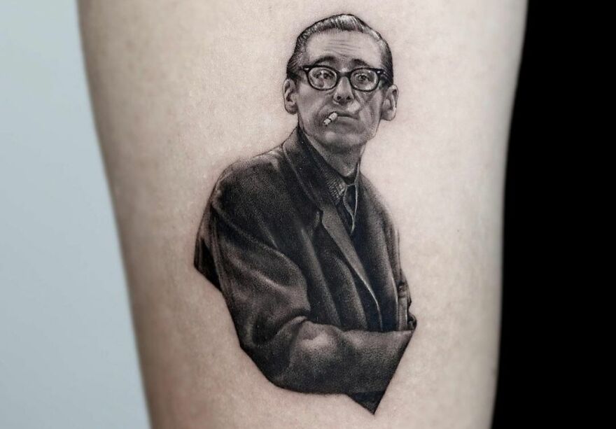 Realistic tattoo of Bill Evans with a cigarette, showcasing intricate detailing.