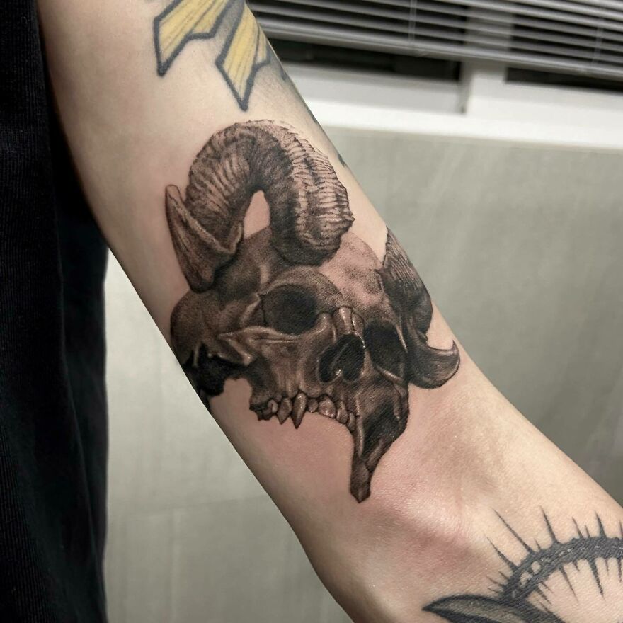 Skull with horns tattoo on arm
