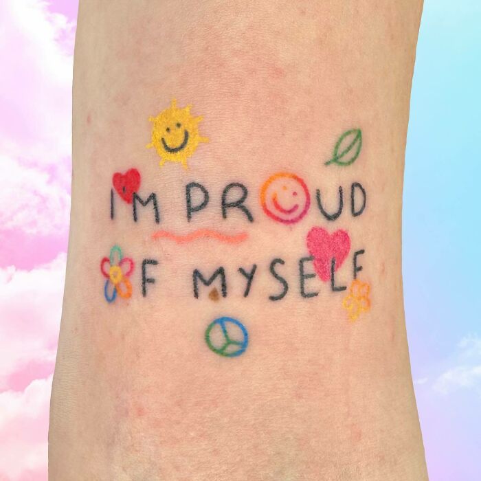 Colorful self-love tattoo with positive symbols like a sun, heart, and flowers, reading "I'm Proud of Myself."