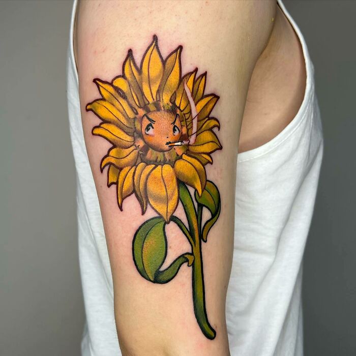Sunflower tattoo on arm radiating elegance and beauty with vibrant colors and playful design.