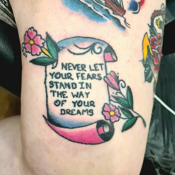 Self-love tattoo with empowering message surrounded by flowers and colorful design.