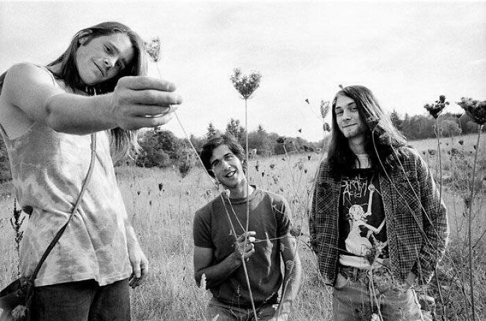Una banda (entonces) poco conocida llamada Nirvana hace una sesión de fotos en un campo (Charles Peterson, 1989)