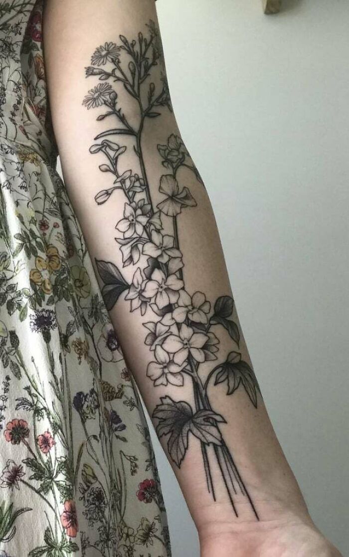 Elegant flower tattoo design on a forearm, showcasing detailed floral patterns.