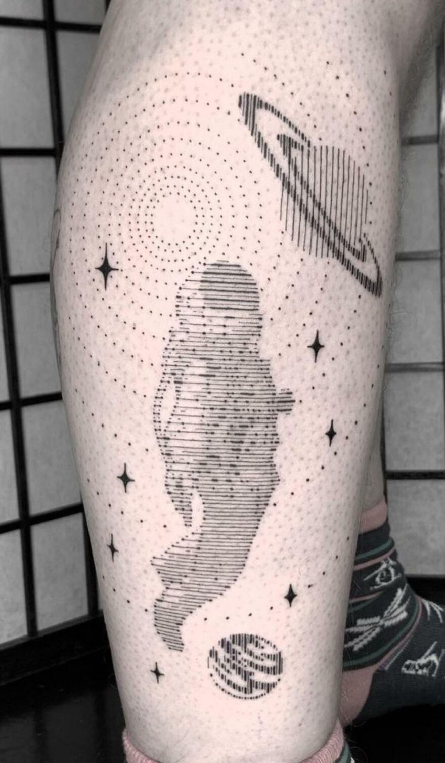 Abstract astronaut in space leg tattoo