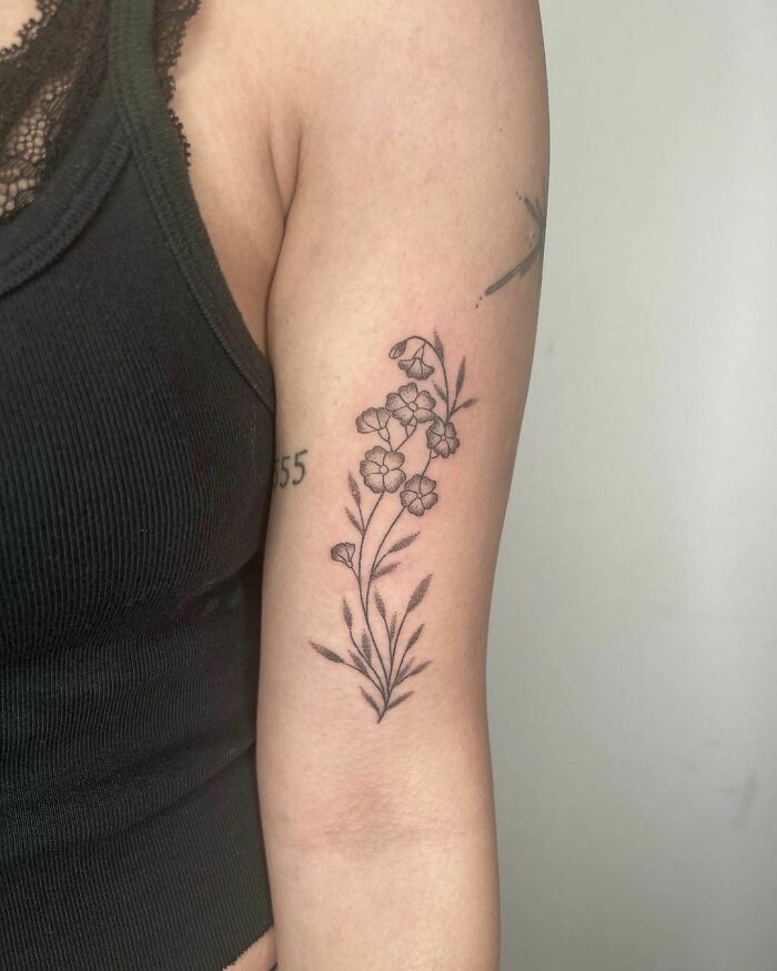 Elegant flower tattoo on arm showcasing floral beauty and intricate design.