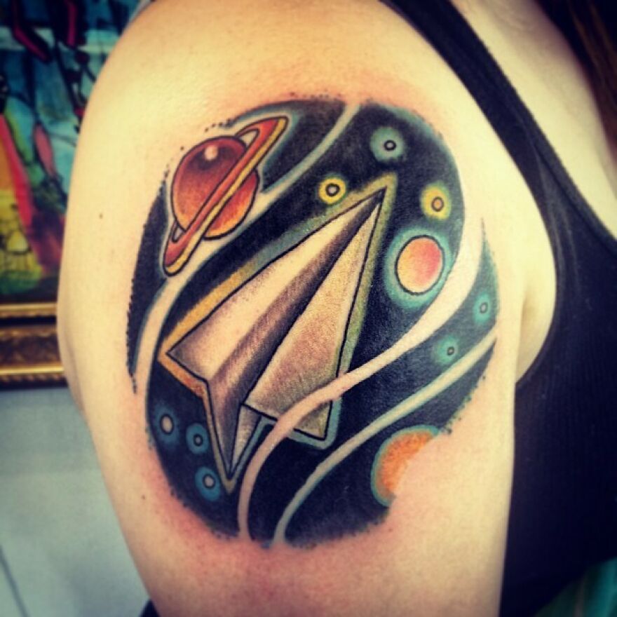 Paper airplane in space shoulder tattoo