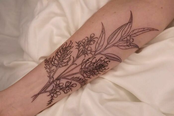 Elegant flower tattoo on forearm, showcasing detailed botanical design.