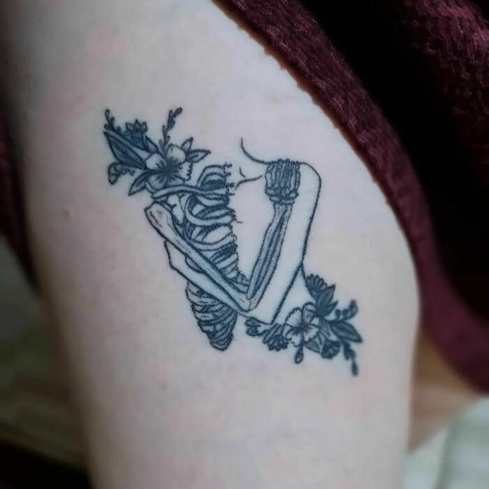 Broken skeleton with flowers leg tattoo