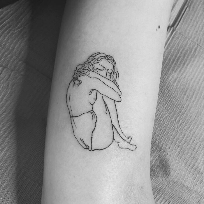 Woman hugging herself tattoo 