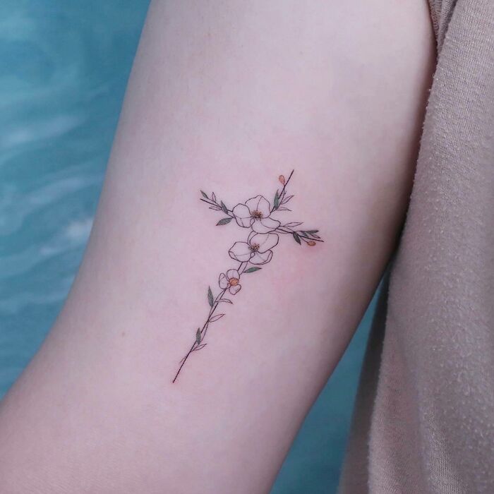 Delicate floral tattoo on arm, showcasing elegance and beauty.