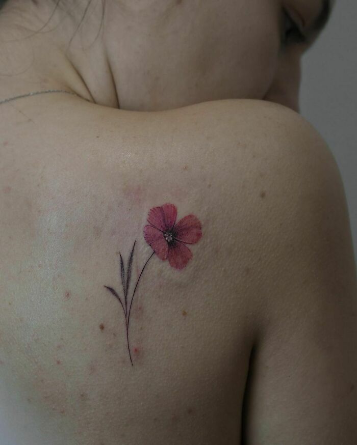 Elegant flower tattoo on shoulder, showcasing beauty and simplicity.