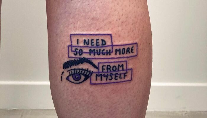 Self-love tattoo featuring an eye design and the text "I need so much more from myself" on a person's leg.