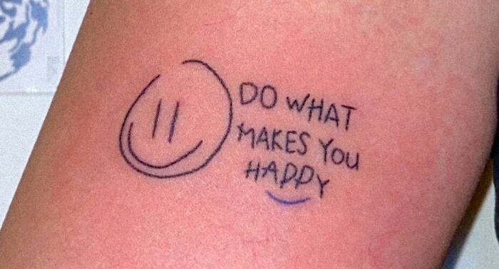 Self-love tattoo featuring a smiley face and the phrase "Do what makes you happy" on skin.