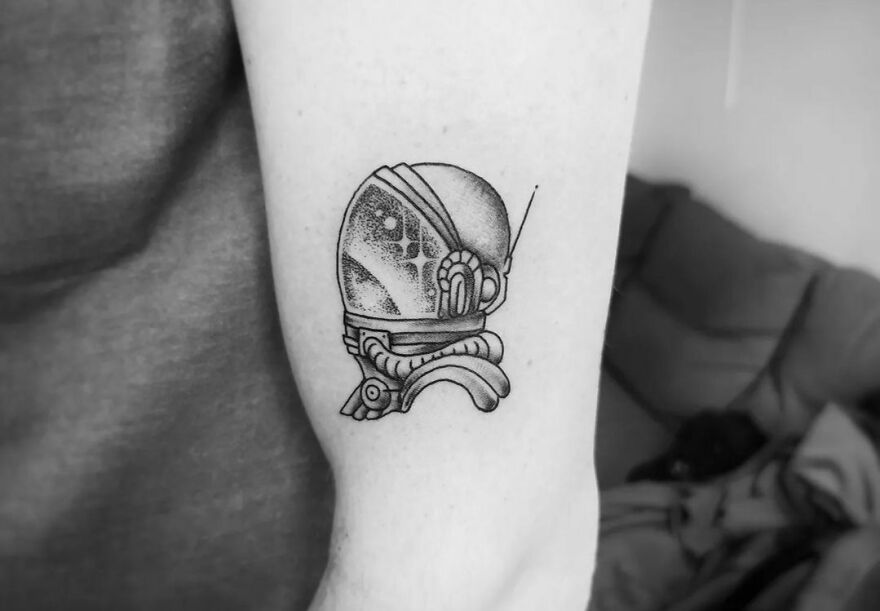Astronaut head arm tattoo
