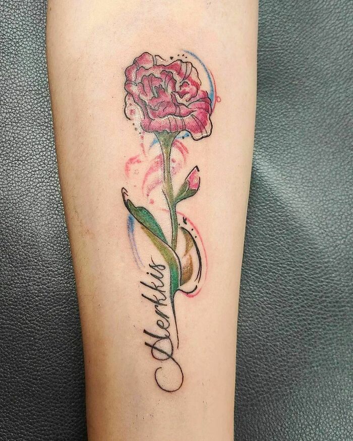 Elegant flower tattoo with vibrant colors on forearm, showcasing beauty and artistry.