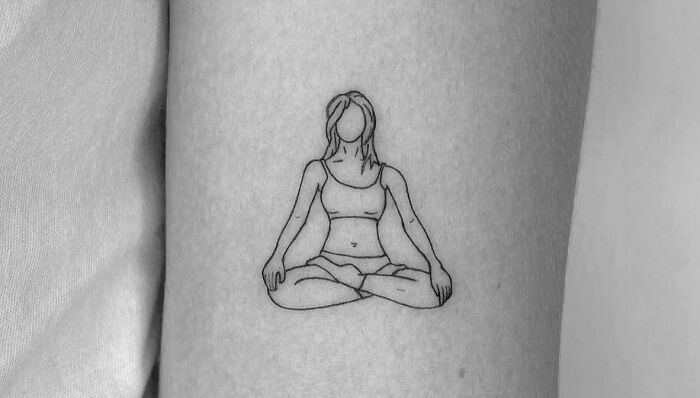 Person in lotus pose arm tattoo