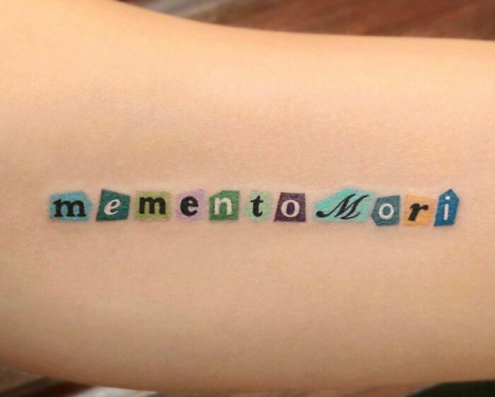 Colorful "memento mori" tattoo on arm, showcasing unique self-love tattoo idea.