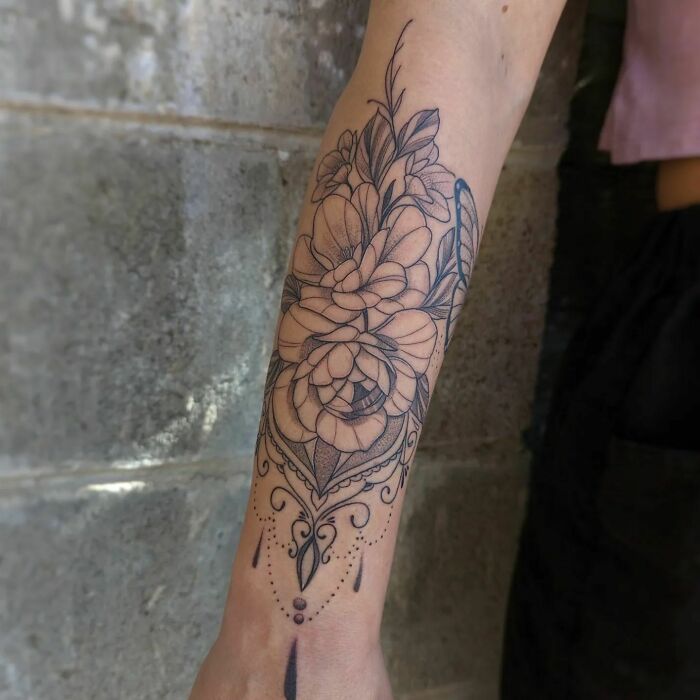 Elegant flower tattoo on forearm with intricate design, showcasing beauty and artistry.
