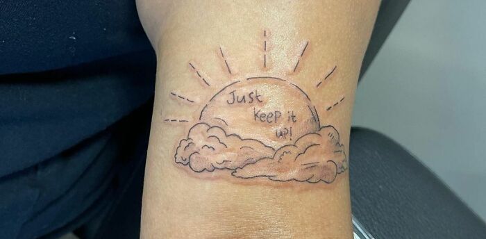 Just keep it up quote in sun with clouds arm tattoo