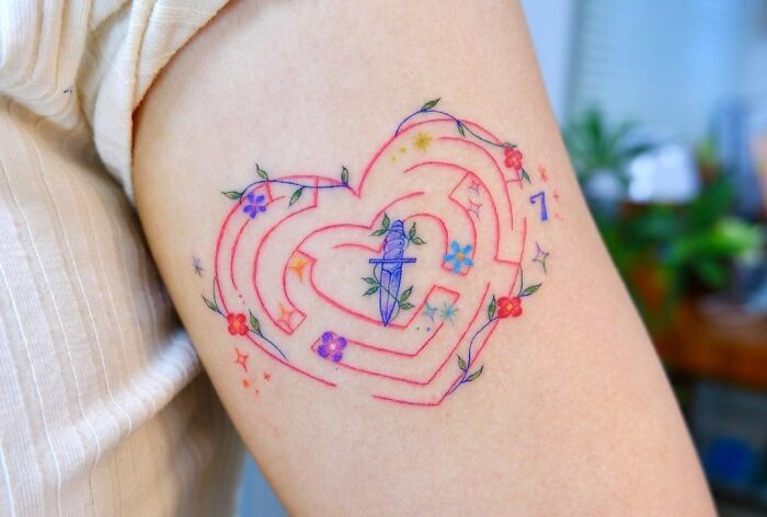 Heart maze with knife inside arm tattoo