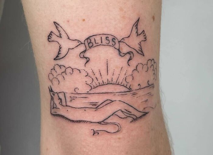 Self-love tattoo with a figure relaxing, sunrise, and doves holding a "Bliss" banner.