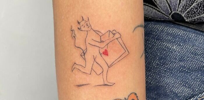 Self-love tattoo featuring a playful devil carrying a heart in a box, symbolizing empowerment and personal meaning.