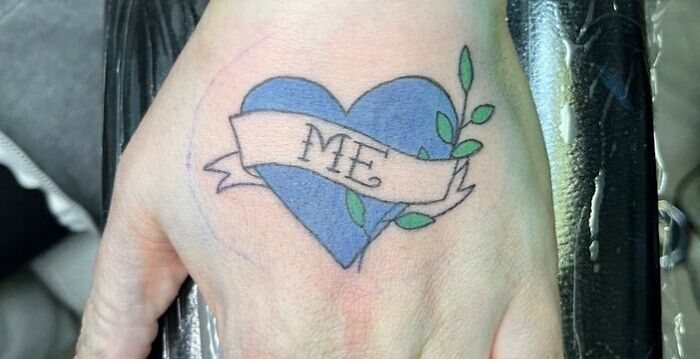 Blue heart with leaves arm tattoo