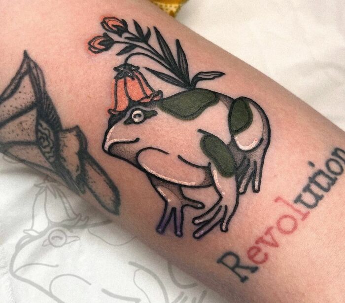 "Revolution" word and a frog tattoo 