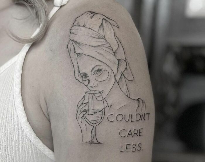 Could'nt care less quote with woman drinking wine shoulder tattoo