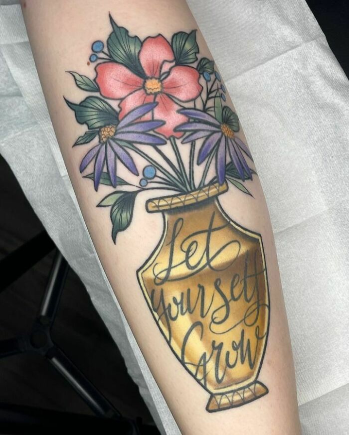 Colorful floral self-love tattoo on arm with vase text “Let yourself grow.”