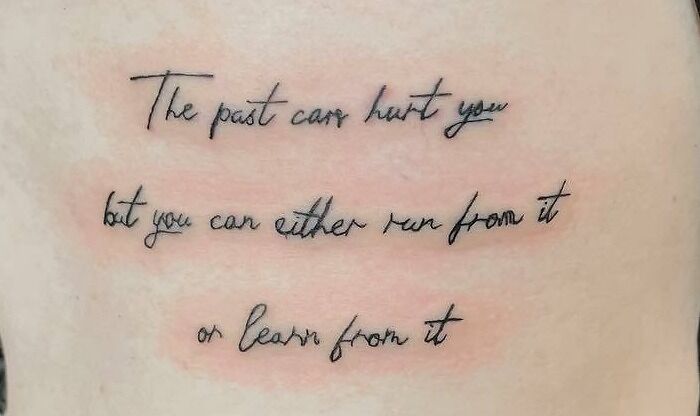 Inspirational self-love tattoo quote on skin in cursive font.