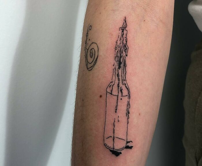 Minimalist self-love tattoo of a dripping bottle and spiral on forearm.