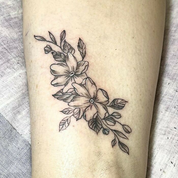 Elegant flower tattoo design with delicate petals and leaves.